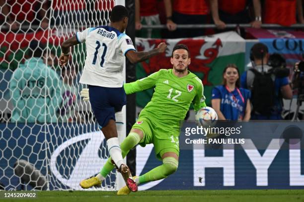 Wales' goalkeeper Danny Ward denies England's forward Marcus Rashford a goal during the Qatar 2022 World Cup Group B football match between Wales and...
