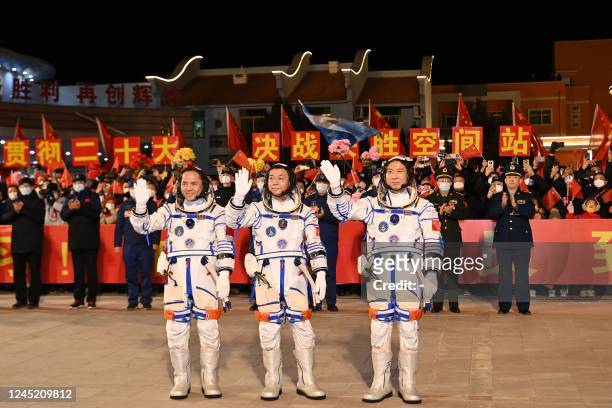 Chinese astronauts Fei Junlong, Deng Qingming and Zhang Lu, crew of the Shenzhou-15 spaceflight mission, wave during a ceremony prior to the launch...