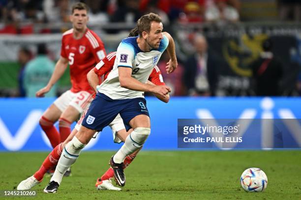 England's forward Harry Kane and Wales' forward Daniel James fight for the ball during the Qatar 2022 World Cup Group B football match between Wales...