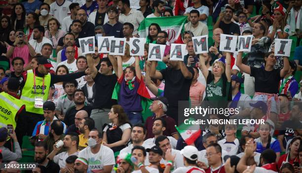 Iranian supporters hold letters forming the name Mahsa Amini as a government protest at a soccer game between Iran and USA, the third and last game...