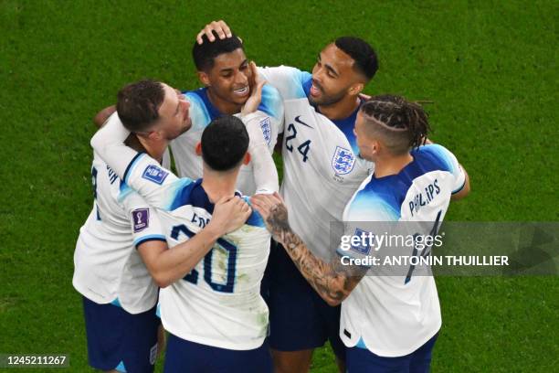 England's forward Marcus Rashford celebrates with teammates after scoring his team's third goal during the Qatar 2022 World Cup Group B football...