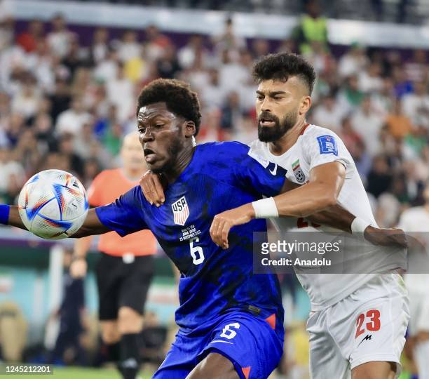Yunus Musah of USA in action against Ramin Rezaeian of Iran during the FIFA World Cup Qatar 2022 Group B match between Iran and USA at Al Thumama...