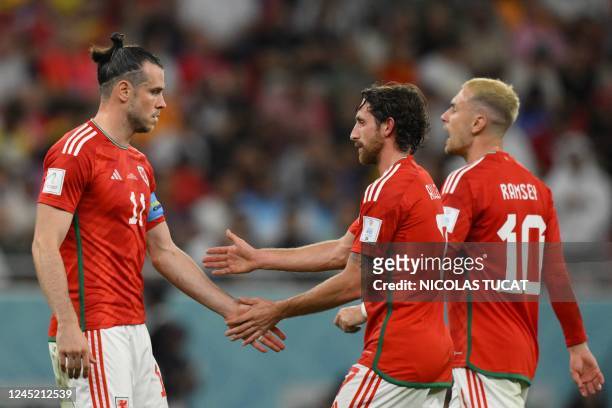 Wales' forward Gareth Bale, Wales' midfielder Joe Allen and Wales' midfielder Aaron Ramsey walk during the Qatar 2022 World Cup Group B football...