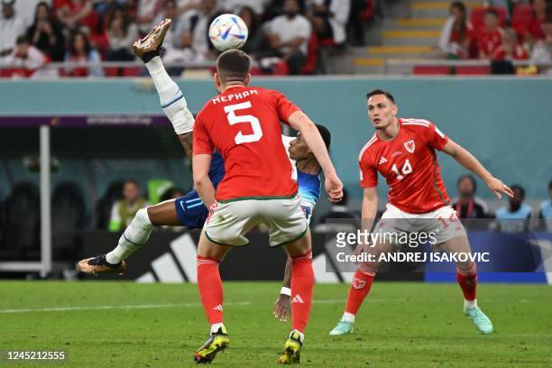 England's forward Marcus Rashford kicks the ball in the air in an attempt to score as Wales' defender Chris Mepham and Wales' defender Connor Roberts...