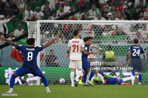 S midfielder Weston McKennie celebrates his team's first goal scored by USA's forward Christian Pulisic reacting on the ground after injuring himself...