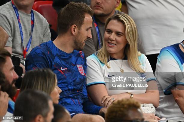 England's forward Harry Kane talks with his wife Katie Goodland after defeating Wales 3-0 in the Qatar 2022 World Cup Group B football match between...