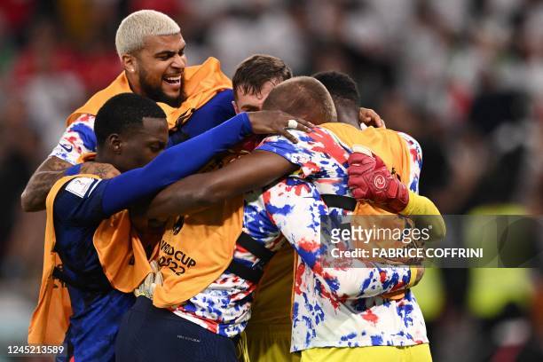 S teammates celebrate at the end of the Qatar 2022 World Cup Group B football match between Iran and USA at the Al-Thumama Stadium in Doha on...