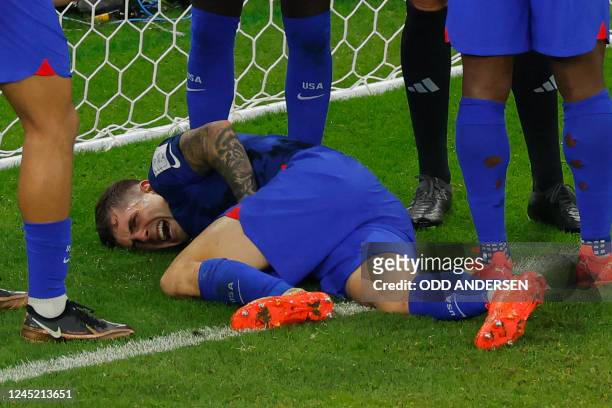 S forward Christian Pulisic reacts following a collision during the Qatar 2022 World Cup Group B football match between Iran and USA at the...