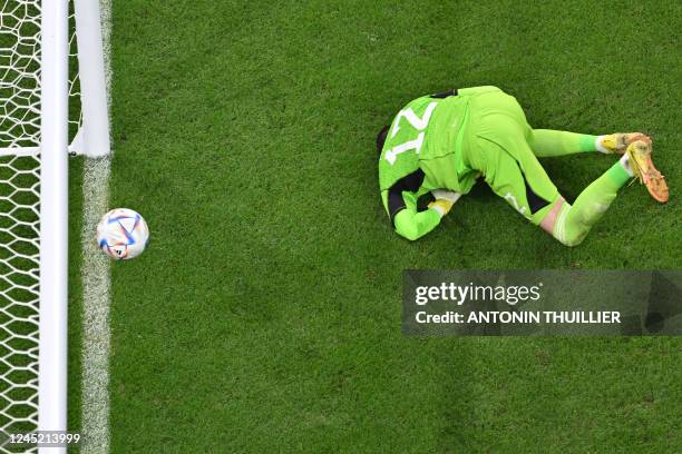 Wales' goalkeeper Danny Ward concedes a goal by England's forward Marcus Rashford from a free-kick during the Qatar 2022 World Cup Group B football...