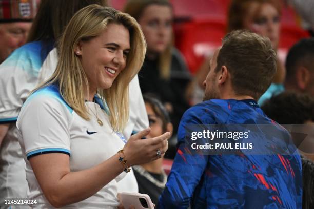 England's forward Harry Kane talks with his wife Katie Goodland after defeating Wales 3-0 in the Qatar 2022 World Cup Group B football match between...