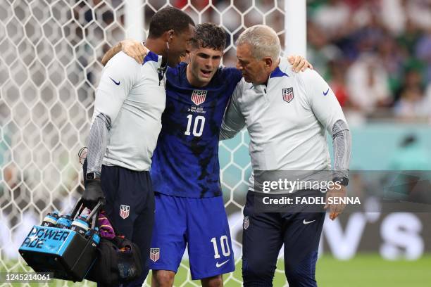 S forward Christian Pulisic receives medical attention after injuring himself while scoring his team's first goal during the Qatar 2022 World Cup...