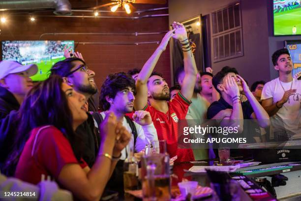 Iranian fans react as they watch the Qatar 2022 World Cup Group B football match between the United States and Iran being shown at a bar in the...