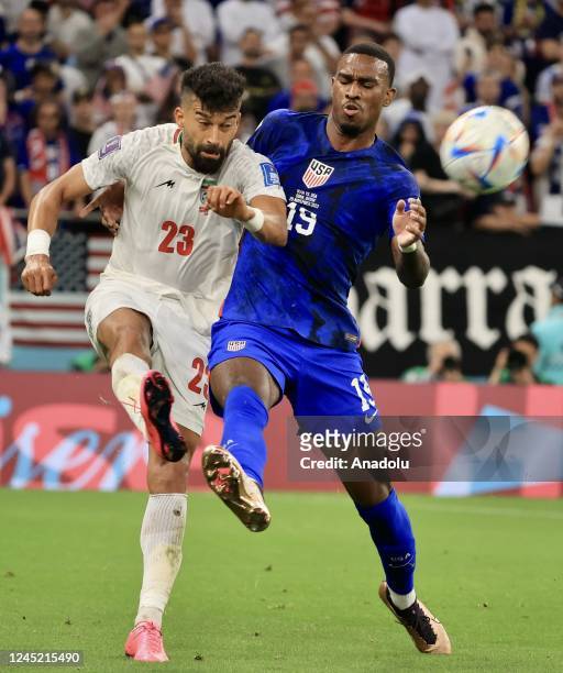 Haji Wright of USA in action against Ramin Rezaeian of Iran during the FIFA World Cup Qatar 2022 Group B match between Iran and USA at Al Thumama...