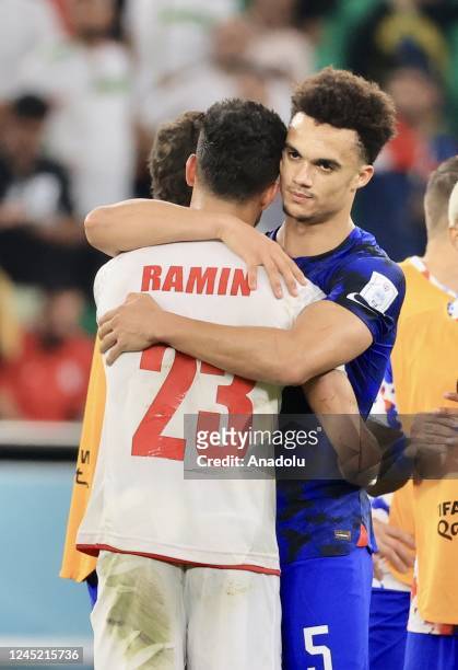 Antonee Robinson of USA gives solace to Ramin Rezaeian of Iran after the FIFA World Cup Qatar 2022 Group B match between Iran and USA at Al Thumama...