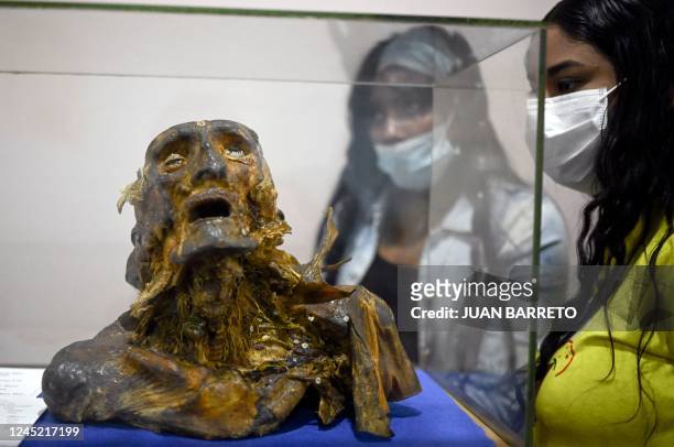 Visitors look at a mummified human torso and head at the Museo del Ser Humano , in Bogota on November 25, 2022. - Deformed fetuses, dissected brains...