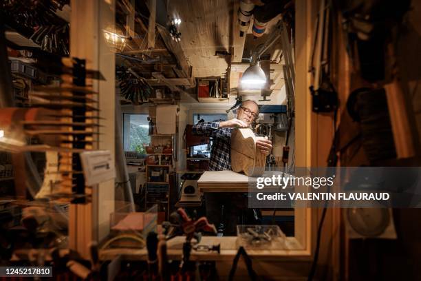 Instrument maker Philippe Ramel sands the soundboard of a guitar, mainly built out of wood from the Risoux forest, in his workshop in Chardonne on...