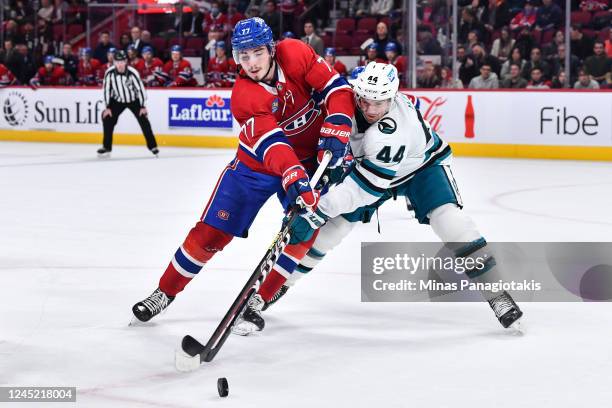 Kirby Dach of the Montreal Canadiens and Marc-Edouard Vlasic of the San Jose Sharks skate after the puck during the second period at Centre Bell on...