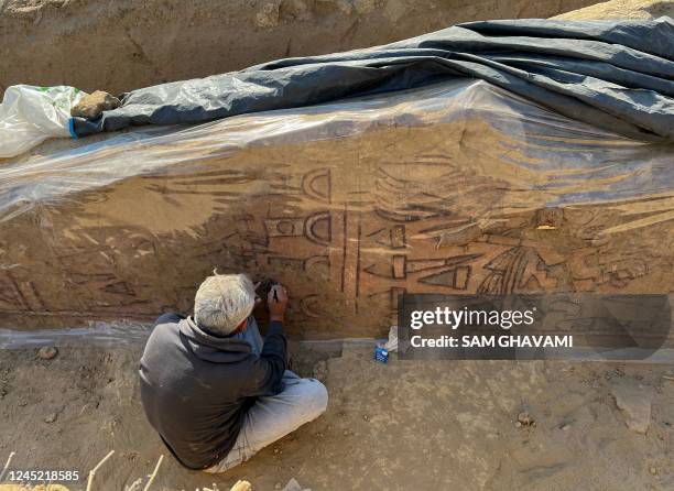 An undated picture shows an archeologist uncovering a pre-Hispanic wall painting with mythological scenes uncovered near the Lambayeque town of...