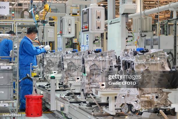 Workers make auto parts on a production line at SAIC-GM Dongyue Automobile Co in Yantai, East China's Shandong province, Nov 17, 2022. China's...