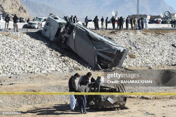 Security officials inspect a burnt car after a suicide bomb attack targeting a police truck in Quetta on November 30, 2022. - Three people were...