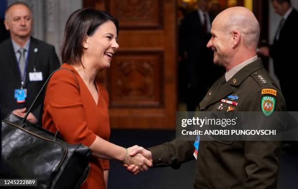 Germany's Foreign Minister Annalena Baerbock shakes hands with US general Christopher Gerard Cavoli, commander of the United States European Command...