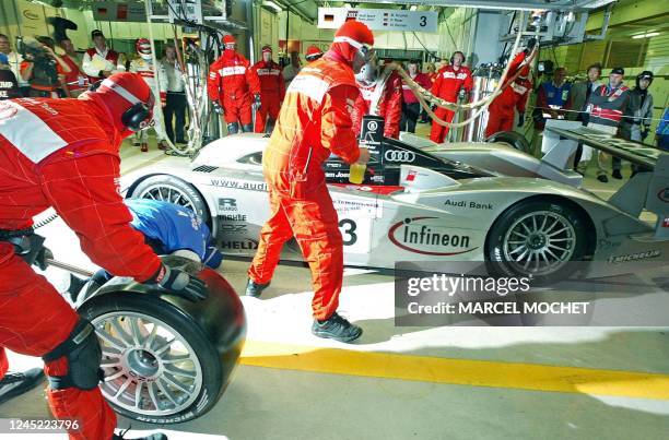 Les mécaniciens de l'équipe Audi effectuent un changement de pneumatiques sur l'Audi n·3 dans la nuit du 15 au 16 juin 2002 au circuit Bugatti du...