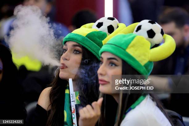 Lebanese women smoke nargileh and watch a streaming broadcast of the FIFA World Cup 2022 group G soccer match between Brazil and Switzerland, at a...