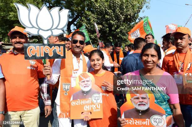 Bhartiya Janta Party supporters hold placards with pictures of Indian Prime Minister Narendra Modi during a roadshow attended by BJP National...