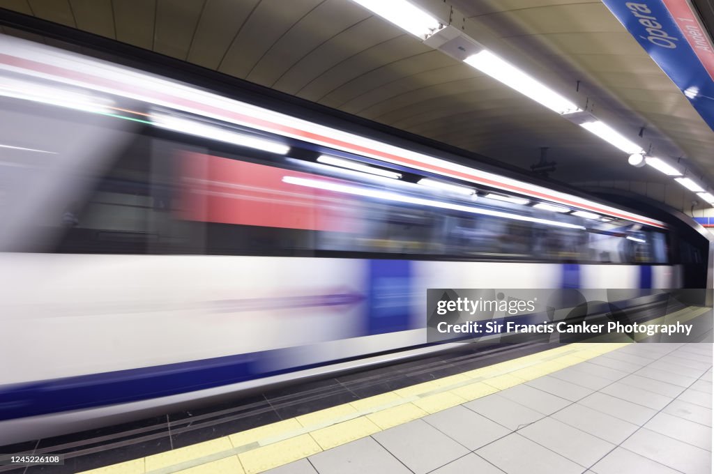 Blurred blue metro train passing fast thru a subway station in Madrid, Spain
