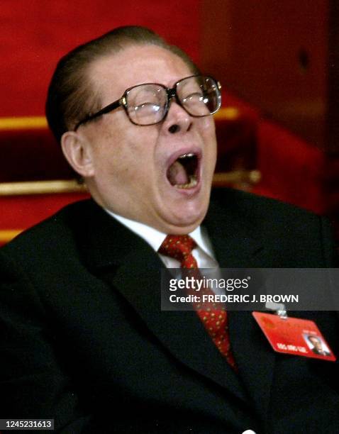 Former Chinese President Jiang Zemin yawns during voting at the National People's Congress in the Great Hall of the People in Beijing 17 March 2003....