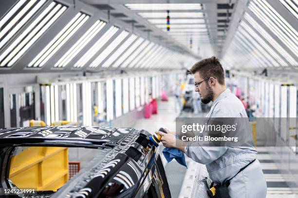 Worker polishes the finish of a Land Rover Defender sport utility vehicle during a paintshop quality control area at the Jaguar Land Rover Plc...