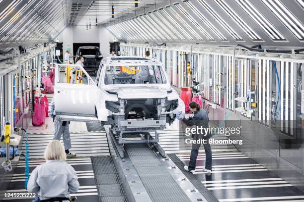 Workers polish the finish of a Land Rover Defender sport utility vehicle during a paintshop quality control area at the Jaguar Land Rover Plc...