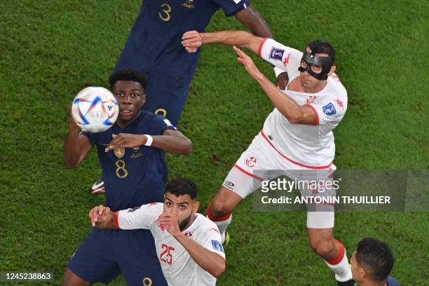 France's midfielder Aurelien Tchouameni, Tunisia's midfielder Ellyes Skhiri and Tunisia's forward Anis Ben Slimane eye the ball during the Qatar 2022...