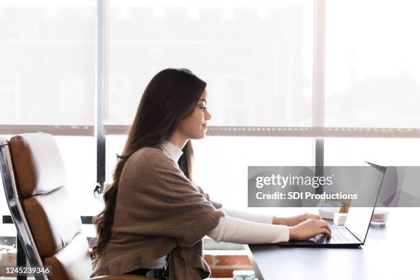 Confident young woman sitting at her desk stock photo (125531