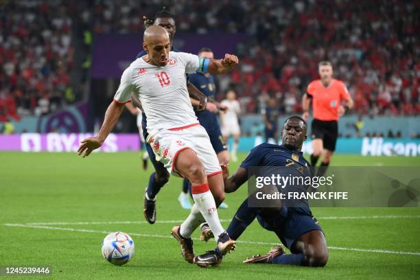 Tunisia's forward Wahbi Khazri is tackled by France's defender Ibrahima Konate during the Qatar 2022 World Cup Group D football match between Tunisia...