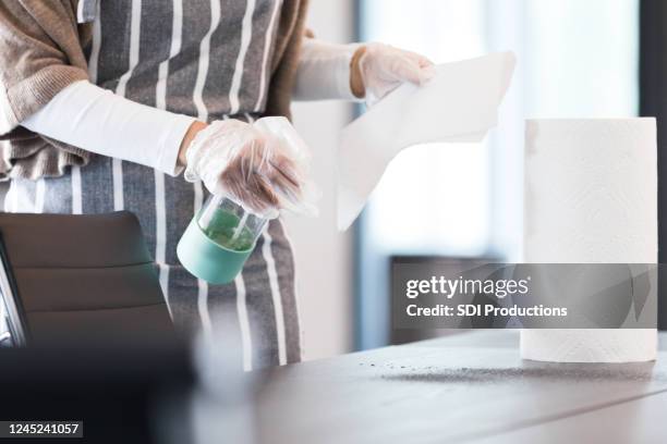 büromitarbeiter reinigt konferenzraumtisch - küchenrollenpapier stock-fotos und bilder