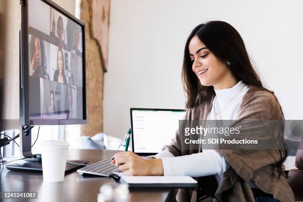 creative professional takes notes during virtual meeting - employee engagement stock pictures, royalty-free photos & images