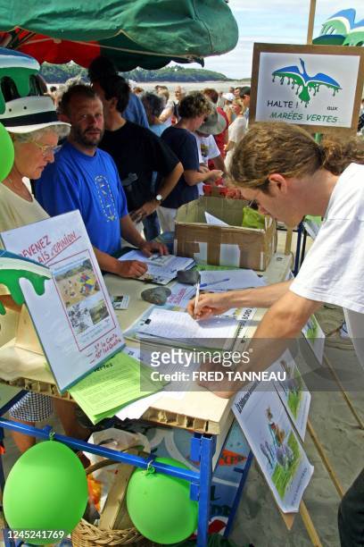 Une personne signe une pétition, le 12 août 2001 sur la plage Saint-Efflam à Plestin-les-Grèves, lors d'une manifestation contre la prolifération des...
