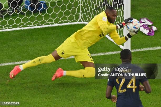 France's goalkeeper Steve Mandanda catches the ball during the Qatar 2022 World Cup Group D football match between Tunisia and France at the...