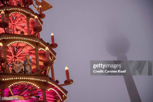 Wooden figures stand on several floors in a Christmas pyramid at the annual Christmas market at Alexanderplatz, close to the Berliner Fensehturm ,...