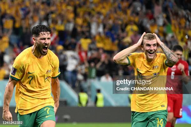 Australia's forward Mathew Leckie celebrates scoring his team's first goal beside teammate midfielder Riley McGree during the Qatar 2022 World Cup...