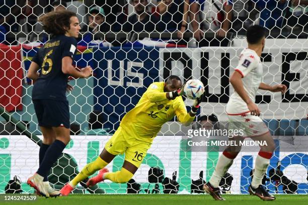 France's goalkeeper Steve Mandanda saves a shot during the Qatar 2022 World Cup Group D football match between Tunisia and France at the Education...