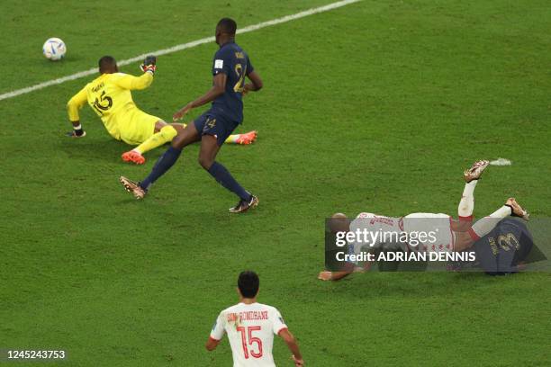 Tunisia's forward Wahbi Khazri falls as he scores his team's first goal past France's goalkeeper Steve Mandanda during the Qatar 2022 World Cup Group...