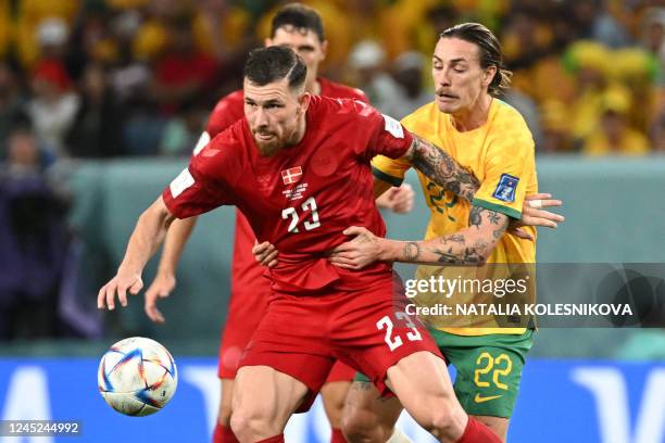 Denmark's midfielder Pierre-Emile Hojbjerg and Australia's midfielder Jackson Irvine fight for the ball during the Qatar 2022 World Cup Group D...