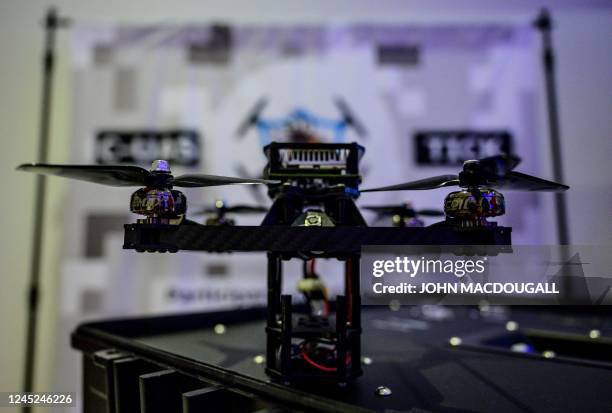 Drone sits on its charger at a stand at the Berlin Security Conference on European Security and Defence, on November 30, 2022 in Berlin. - The TICK...