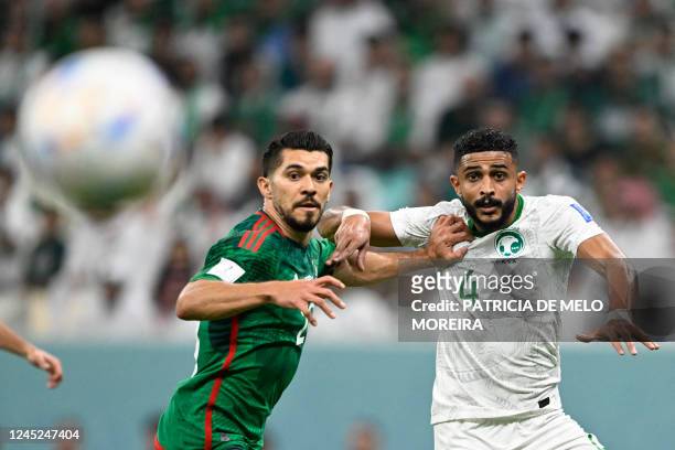 Mexico's forward Henry Martin and Saudi Arabia's defender Abdulelah Al-Amri eye the ball during the Qatar 2022 World Cup Group C football match...