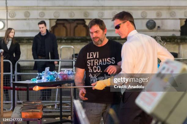 British Chancellor of the Exchequer Jeremy Hunt makes a glass bauble as he visits a Christmas food and drinks market set up in Downing Street to...