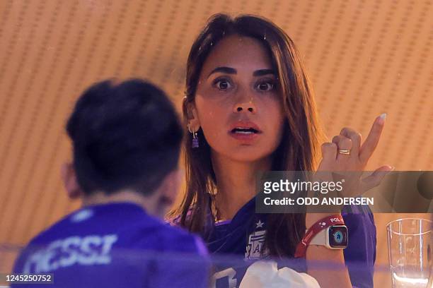 Argentina's forward Lionel Messi's wife Antonela Roccuzzo talks to her son as she waits for the start of the Qatar 2022 World Cup Group C football...