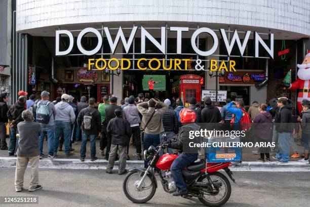 Football fans of Mexico watch the Qatar 2022 World Cup Group C football match between Mexico and Saudi Arabia on the street outside a food court in...