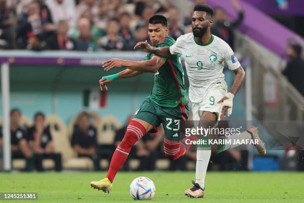 Mexico's defender Jesus Gallardo and Saudi Arabia's forward Firas Al-Buraikan fight for the ball during the Qatar 2022 World Cup Group C football...